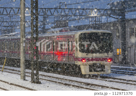 雪の中を走る特急列車　京王線　雪の日　高幡不動駅 112971370