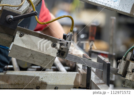 Automatic band saw machine cutting the metal rod with water base coolant method. Automatic band saw machine cutting the metal rod with water base coolant method. 112971572