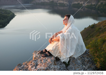 Young man sitting on the rock 112972438