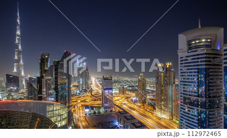 Dubai downtown skyline night timelapse with tallest building and Sheikh Zayed road traffic, UAE 112972465