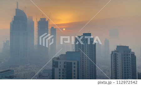 Foggy morning sunrise in downtown of Dubai timelapse. 112972542
