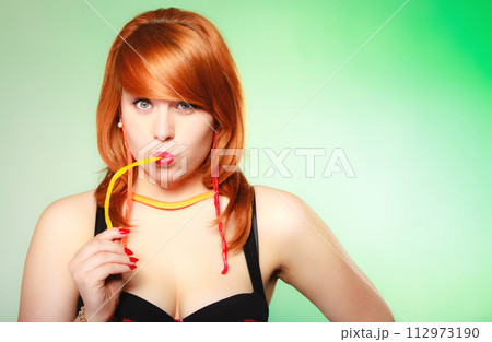 Redhair girl holding sweet food jelly candy on green. Redhair girl holding sweet food jelly candy on green. 112973190