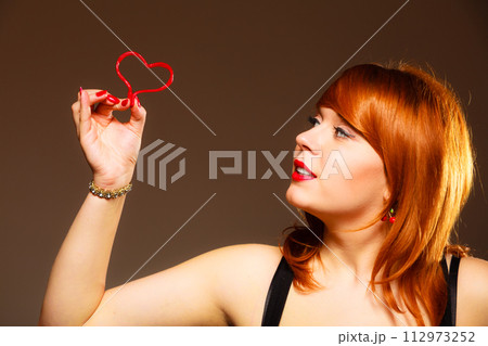 Gorgeous young woman holding candy heart. Gorgeous young woman holding candy heart. 112973252