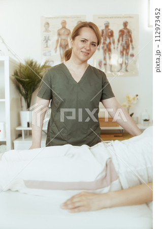 therapist woman in massage cabinet conducting examination 112973452
