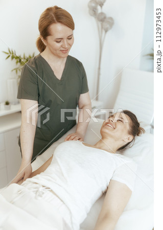 smiling therapist woman in massage cabinet doing checkup smiling therapist woman in massage cabinet doing checkup 112973453