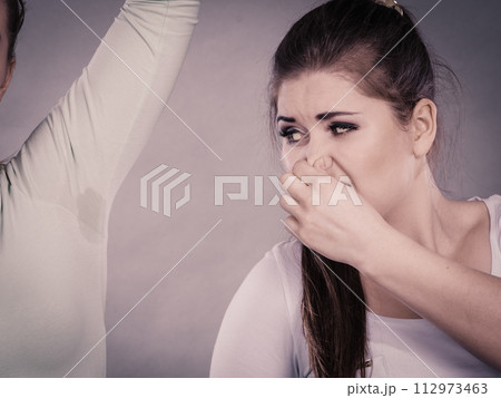Woman having wet armpit her friend smelling stink 112973463