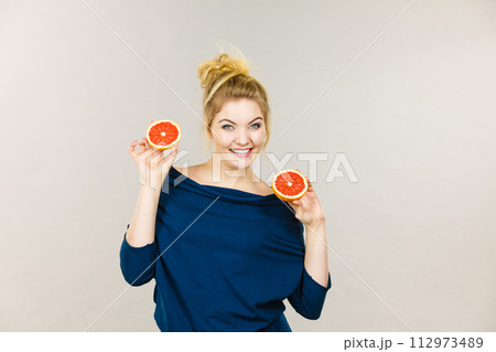 Happy smiling woman holding red grapefruit Happy smiling woman holding red grapefruit 112973489