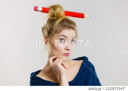 Thinking blonde woman having big pencil in hair Thinking blonde woman having big pencil in hair 112973547