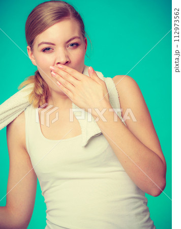 Bored sleepy woman yawning while holding towel 112973562