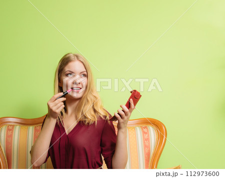 Attractive woman applying lipstick. Make up. 112973600