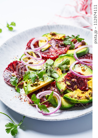 Blood oranges salad with avocado, pistachios and red onions. 112974111