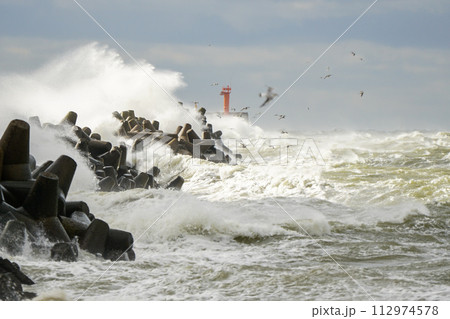 Big wave breaking on breakwater, stormy sea, crashing waves, wave splashing, hurricane season 112974578