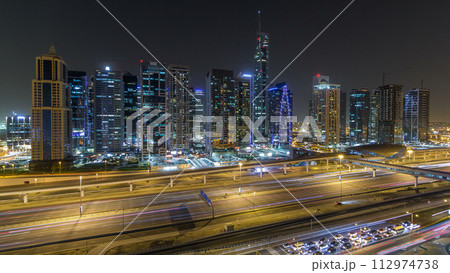 Aerial view of Jumeirah lakes towers skyscrapers night timelapse with traffic on sheikh zayed road. 112974738