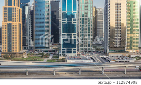 Aerial view of Jumeirah lakes towers skyscrapers timelapse with traffic on sheikh zayed road. 112974908