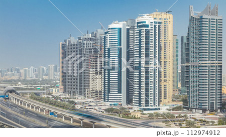 Aerial view of Jumeirah lakes towers skyscrapers timelapse with traffic on sheikh zayed road. Aerial view of Jumeirah lakes towers skyscrapers timelapse with traffic on sheikh zayed road. 112974912