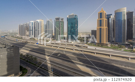 Aerial view of Jumeirah lakes towers skyscrapers timelapse with traffic on sheikh zayed road. 112974920