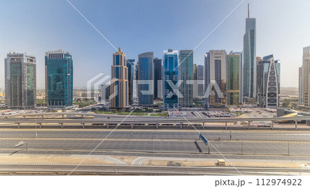 Aerial view of Jumeirah lakes towers skyscrapers all day timelapse with traffic on sheikh zayed road. Aerial view of Jumeirah lakes towers skyscrapers all day timelapse with traffic on sheikh zayed road. 112974922