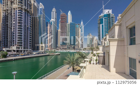 Panoramic view with modern skyscrapers and yachts of Dubai Marina timelapse hyperlapse, United Arab Emirates 112975056