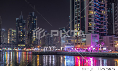 Dubai marina bay with yachts an boats night timelapse 112975073