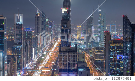 Scenic Dubai downtown skyline at night timelapse. Rooftop view of Sheikh Zayed road with numerous illuminated towers. Scenic Dubai downtown skyline at night timelapse. Rooftop view of Sheikh Zayed road with numerous illuminated towers. 112975491