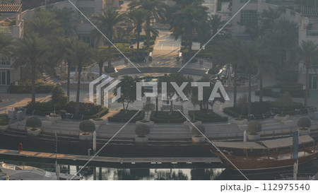 Dubai Marina fountain aeral morning timelapse, port with luxury yachts and marina promenade 112975540