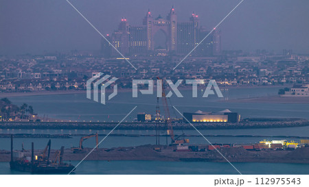 A breathtaking aerial view of the Palm Jumeirah night to day timelapse from a rooftop, Dubai, United Arab Emirates A breathtaking aerial view of the Palm Jumeirah night to day timelapse from a rooftop, Dubai, United Arab Emirates 112975543