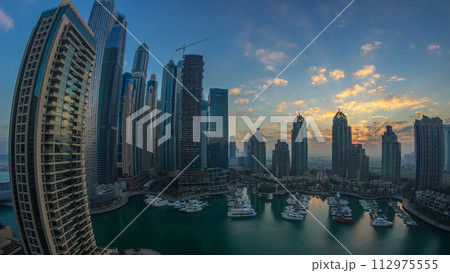 View of modern skyscrapers shining in sunrise lights timelapse in Dubai Marina in Dubai, UAE. 112975555