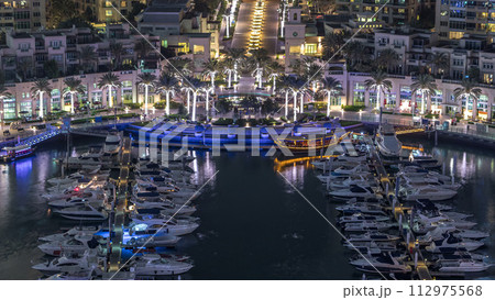 Dubai Marina fountain aerial night timelapse, port with luxury yachts and marina promenade 112975568