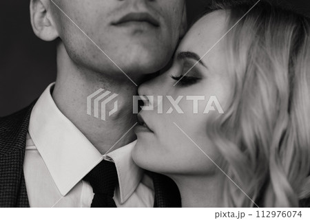 Cute wedding couple in the interior of a classic studio decorated. They kiss and hug each other. Cute wedding couple in the interior of a classic studio decorated. They kiss and hug each other. 112976074