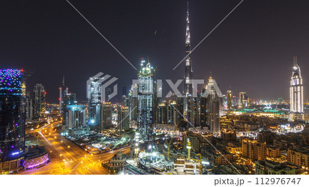 Aerial cityscape timelapse at night with illuminated modern architecture in Downtown of Dubai, United Arab Emirates. 112976747