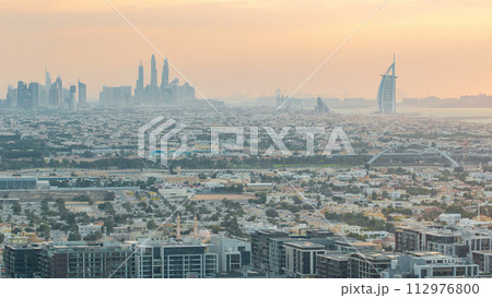 Dubai skyline with Dubai Marina skyscrapers and coastline at sunset timelapse with seven star luxury hotel in Dubai, UAE. 112976800