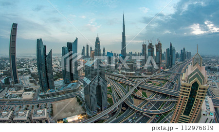 Modern skyscrapers and busy evening highways day to night timelapse in luxury Dubai city, Dubai, United Arab Emirates 112976819