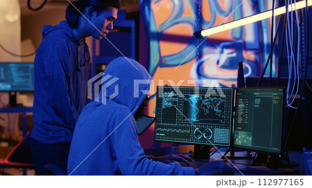 Hackers in dark room trying to steal valuable data by targeting governmental websites with weak security. Evil computer scientists doing cyber attacks to gain access to sensitive info 112977165