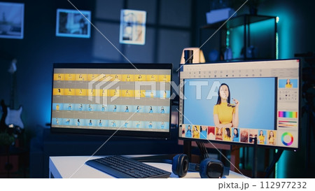 Photo retouching software interface on computer in empty blue neon lit photography studio. Photography organizing program displayed on multi monitors PC setup on multimedia agency desk, zoom out shot 112977232