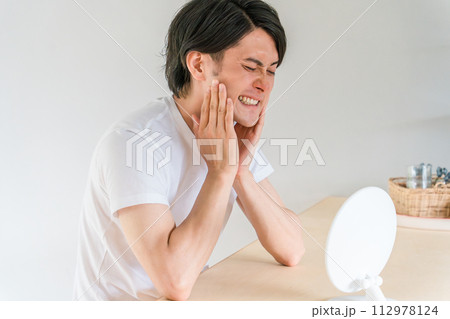 虫歯・歯列矯正・歯周病・歯が気になる若い男性（歯痛） 112978124