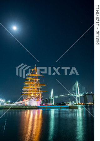 輝く月とライトアップされた光が美しく海面に反射する海王丸パークの夜景｜新湊大橋イメージ｜富山県射水市 112978411