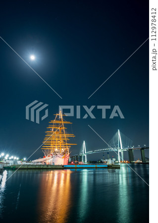 輝く月とライトアップされた光が美しく海面に反射する海王丸パークの夜景｜新湊大橋イメージ｜富山県射水市 112978412