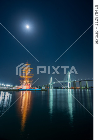 輝く月とライトアップされた光が美しく海面に反射する海王丸パークの夜景｜新湊大橋イメージ｜富山県射水市 112978418
