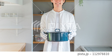 キッチンで鍋を持つ若い男性・料理好きな夫・主夫・料理男子 キッチンで鍋を持つ若い男性・料理好きな夫・主夫・料理男子 112978810
