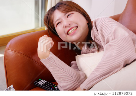 ソファーの上でくつろぐ女性 112979072