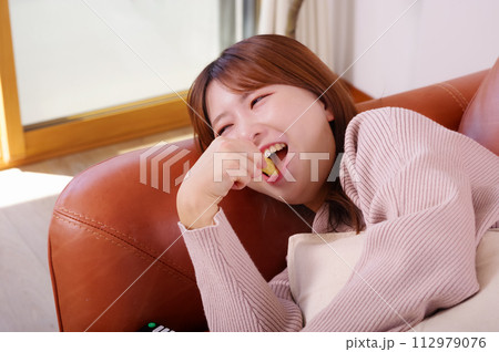 ソファーの上でくつろぐ女性 112979076