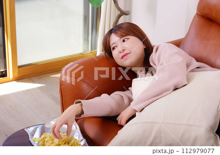 ソファーの上でくつろぐ女性 112979077
