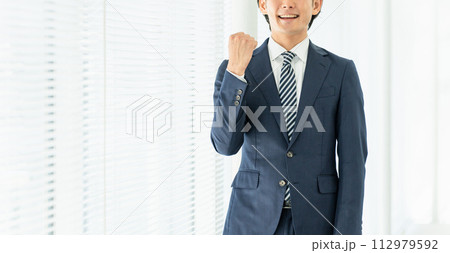 オフィスでガッツポーズする若いアジア人男性ビジネスマン オフィスでガッツポーズする若いアジア人男性ビジネスマン 112979592