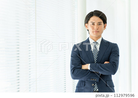 オフィスで腕組みする若いアジア人男性ビジネスマン(自信・誠実・信頼) オフィスで腕組みする若いアジア人男性ビジネスマン(自信・誠実・信頼) 112979596