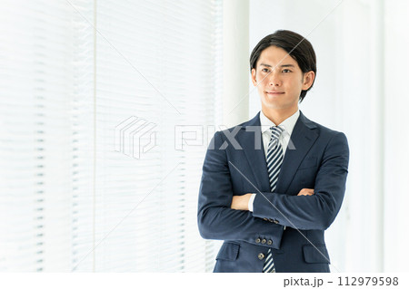 オフィスで腕組みする若いアジア人男性ビジネスマン(自信・信頼) オフィスで腕組みする若いアジア人男性ビジネスマン(自信・信頼) 112979598