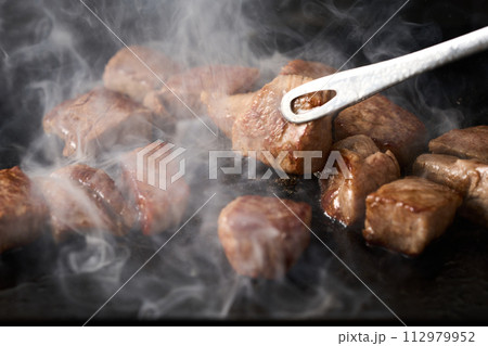 カットステーキを鉄板で焼く 112979952
