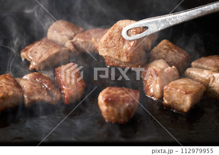 カットステーキを鉄板で焼く 112979955