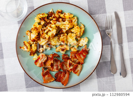 Plate of tasty boiled cauliflower with fried lard and sauce 112980594