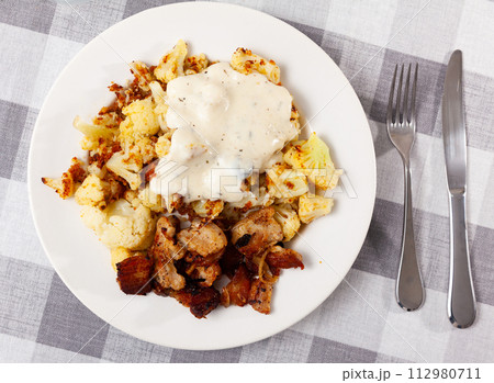 Cauliflower with lard served on plate 112980711