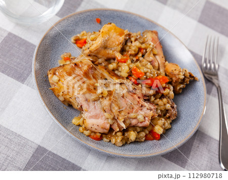 Lunch is served on plate - baked pieces of young rabbit and pearl barley Lunch is served on plate - baked pieces of young rabbit and pearl barley 112980718